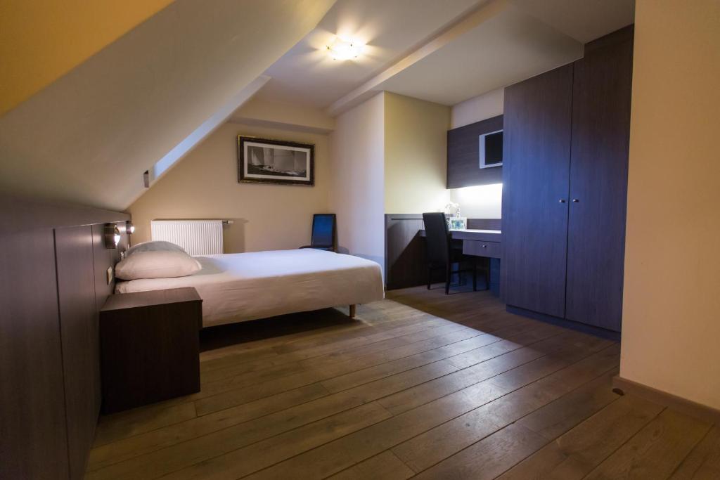 1 dormitorio con cama y escritorio. en Hotel De Spaenjerd, en Kinrooi