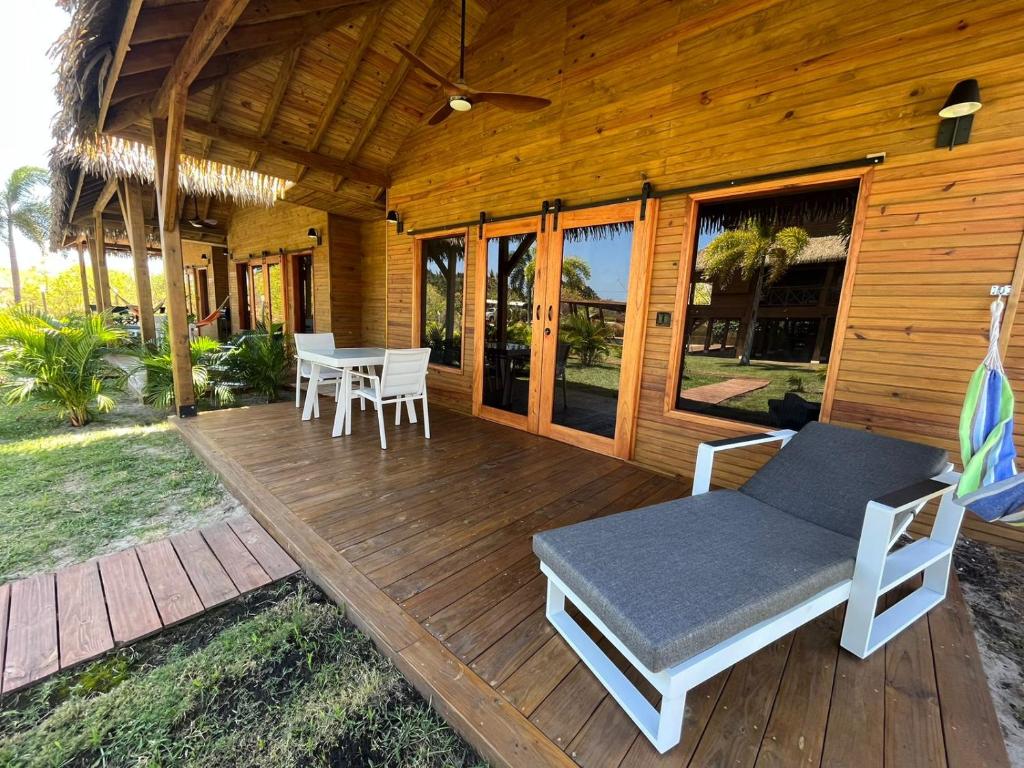 una terraza de madera con mesa y sillas. en Casitas de madera, en Punta Chame