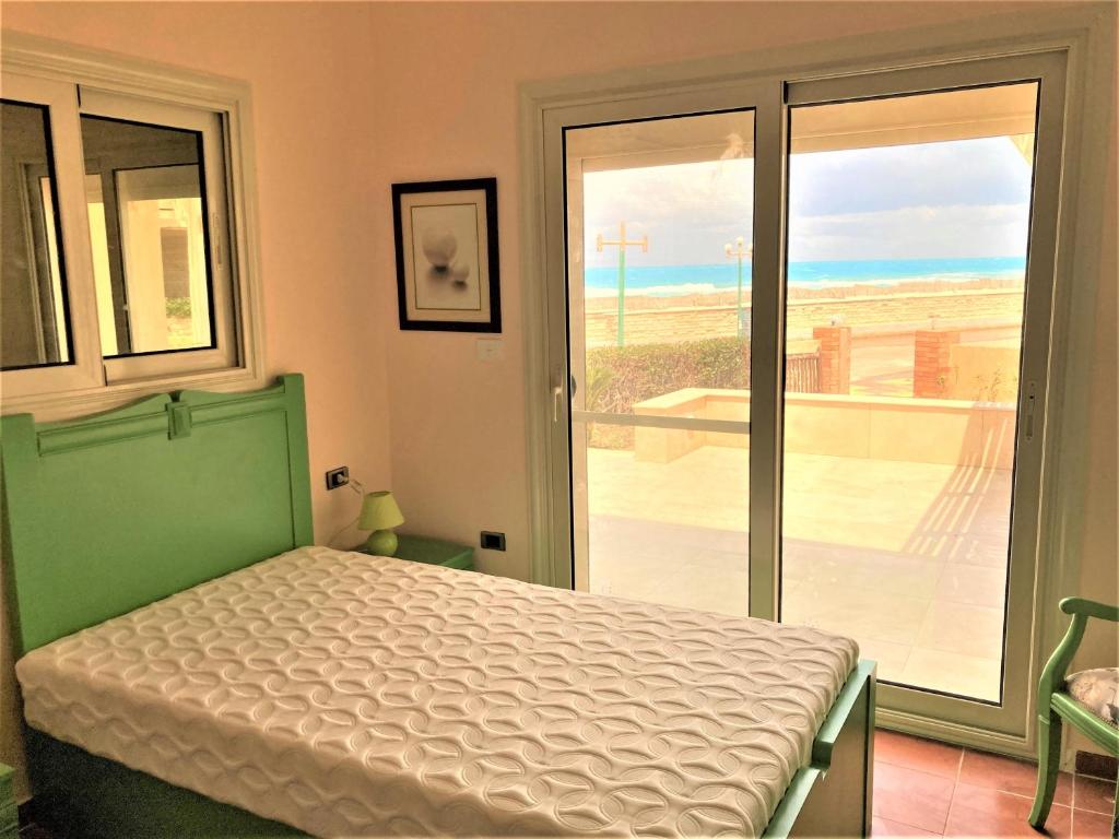 um quarto com uma cama e vista para a praia em Maison sur plage em Al Ḩammām