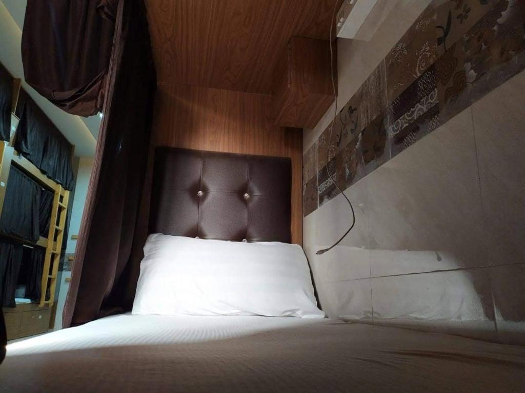 1 cama con cabecero marrón y almohada blanca en Super Champions Hostel, en Bombay