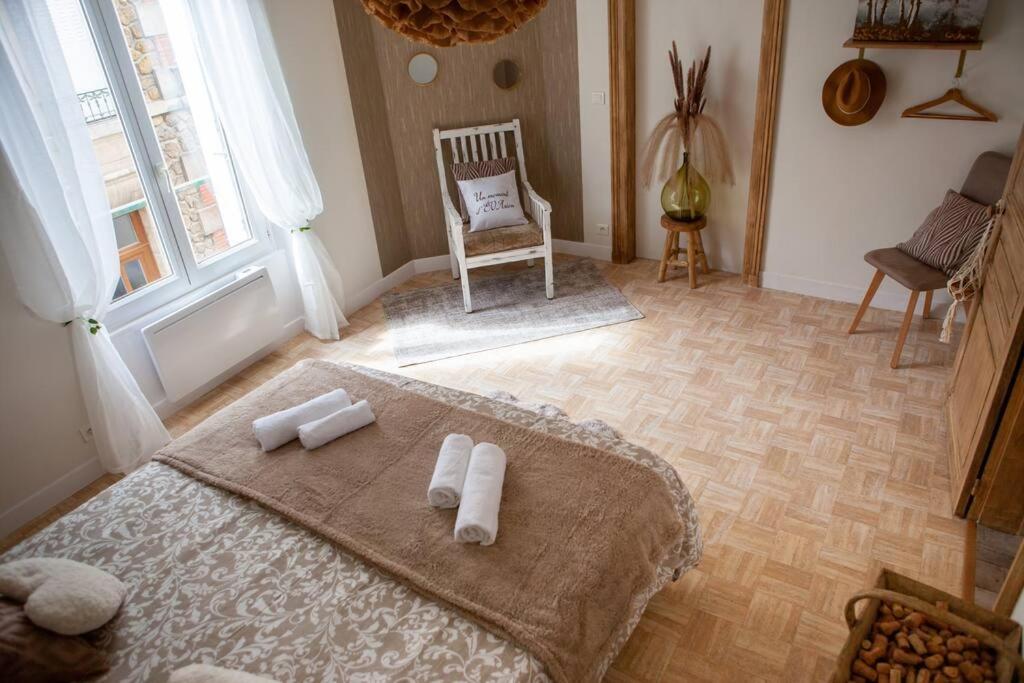 sypialnia z łóżkiem z ręcznikami w obiekcie Appartement Un moment d’ÉVAsion w Épernay
