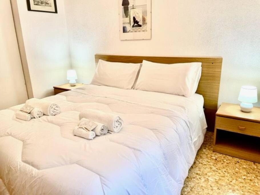 um quarto com uma cama branca e toalhas em Sea at 400mt - station - wi-fi em Laigueglia