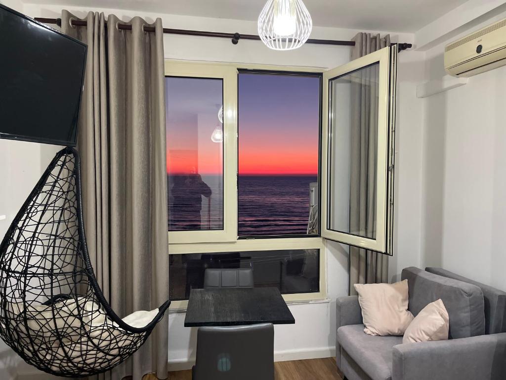 Sala de estar con silla y vistas al océano en Arteg Apartments - Full Sea View en Durrës