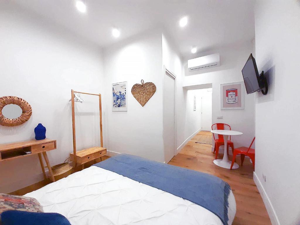 a bedroom with a bed and a table and a tv at The Idyll Boutique Apartment - Spanish Quarter in Naples