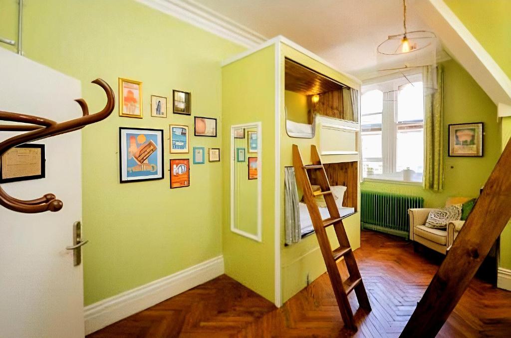 a hallway with green walls and a stair case at Mrs Potts in Cardiff