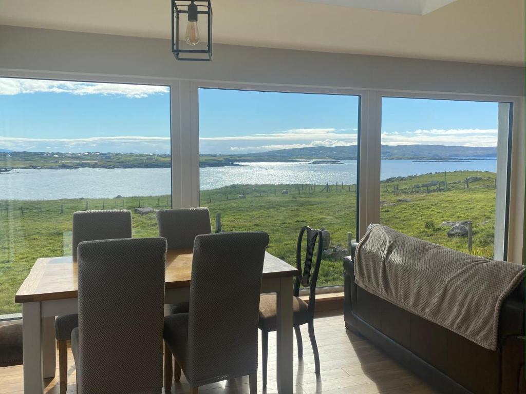a dining room with a table and chairs and a large window at Cruit Island Holiday Rent in Cruit