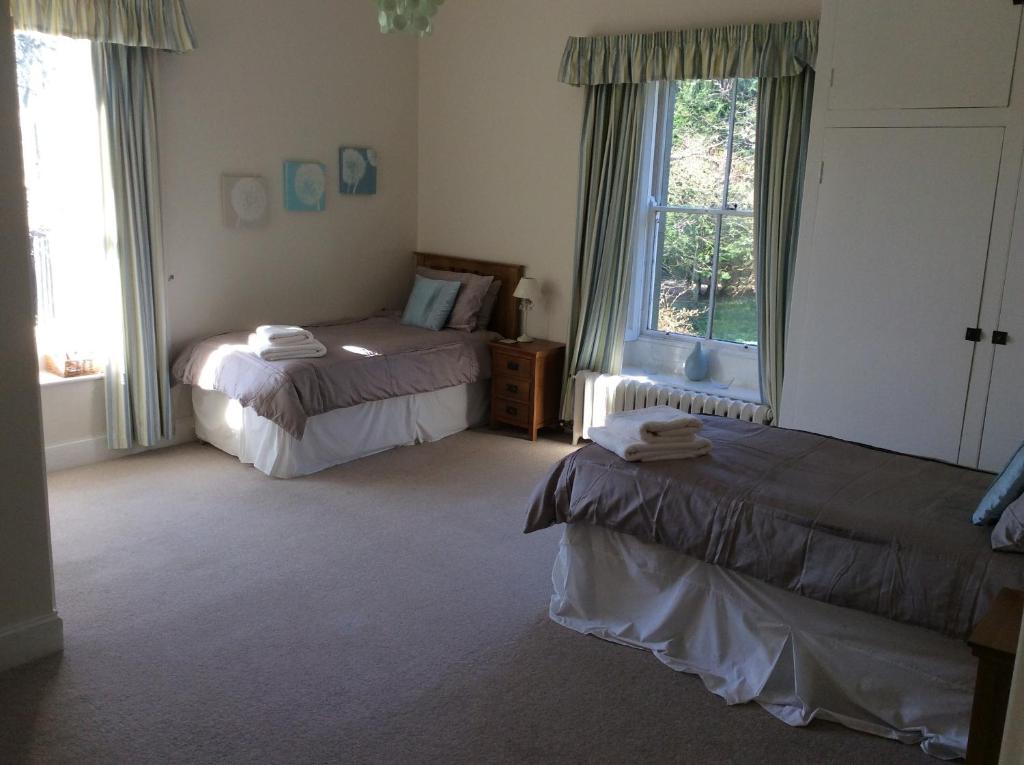 a bedroom with two beds and a window at Rock Moor House B&B in North Charlton