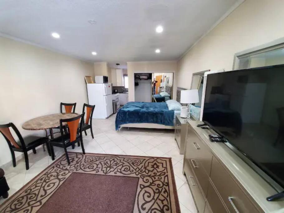 Lovely Single Apartment في لوس أنجلوس: غرفة نوم مع سرير وتلفزيون بشاشة مسطحة كبيرة