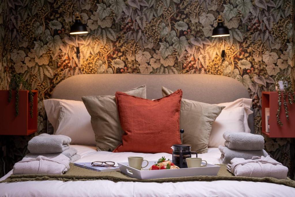 Una cama con almohadas y una bandeja de comida. en The Nest, en Brockenhurst