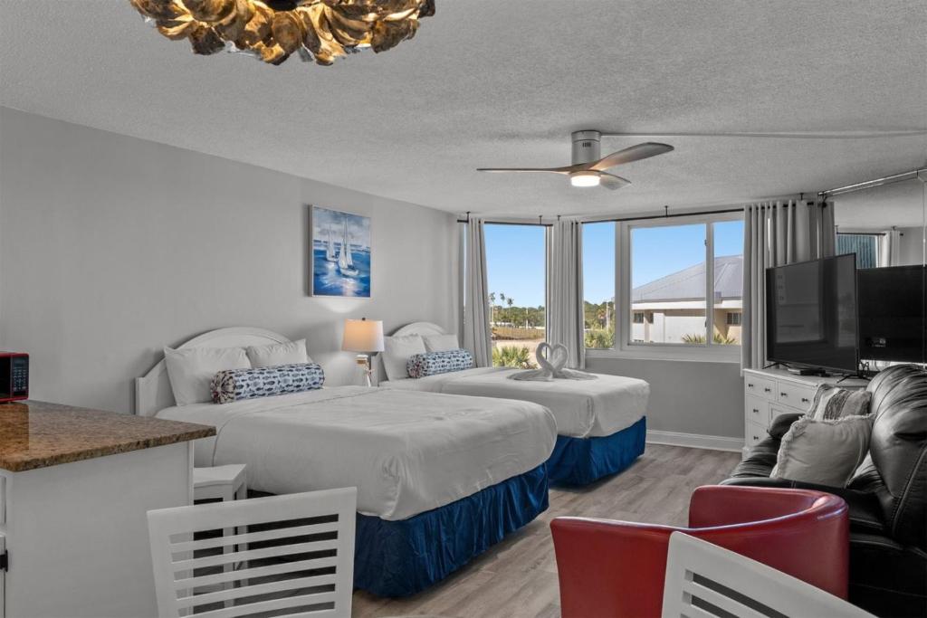 a bedroom with two beds and a flat screen tv at Top of The Gulf 306 in Panama City Beach