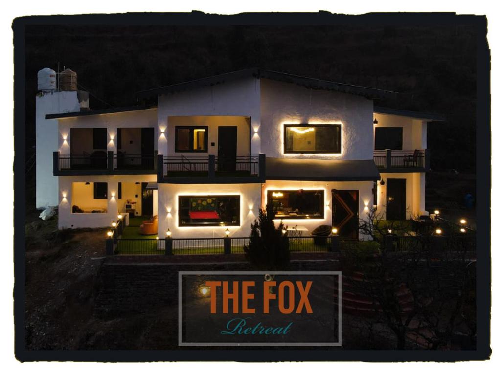 a large white house with a sign in front of it at THE FOX RETREAT in Mukteshwar