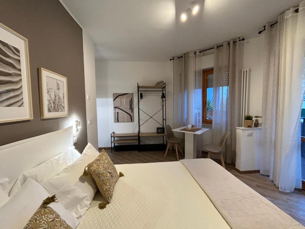 een slaapkamer met een groot wit bed en een bureau bij Mono Sirolo My house in Sirolo