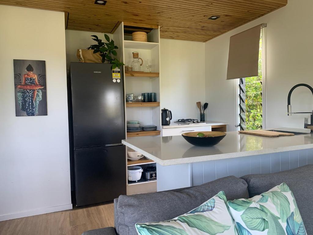 a kitchen with a black refrigerator and a counter at Konini Retreat in Rarotonga