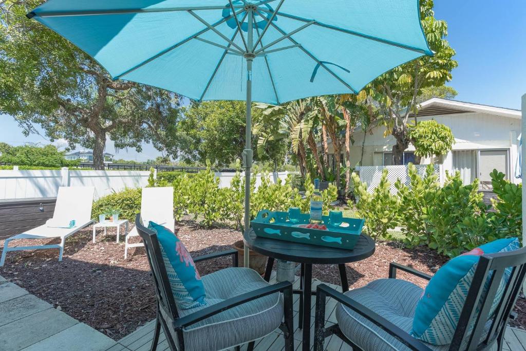 uma mesa com cadeiras e um guarda-sol num pátio em Pelican Gardens Studio 3 on Lido Key em Sarasota