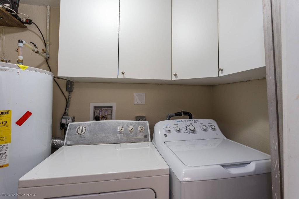 cocina con fogones y armarios blancos en Coastal Breeze Siesta Manatee "C", en Sarasota