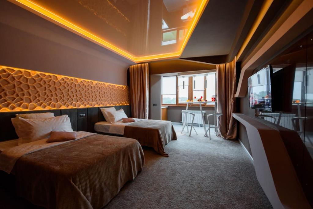 ein Hotelzimmer mit 2 Betten und einem Tisch in der Unterkunft Апартаменты Радужный берег in Turksib
