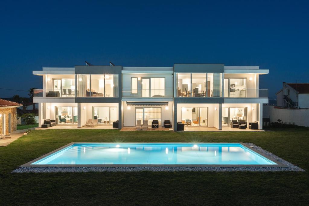 une grande maison avec une piscine en face de celle-ci dans l'établissement SilverSide Holidays, à Caldas da Rainha
