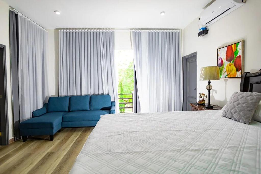 een slaapkamer met een groot bed en een blauwe bank bij Hotel, Cocoview Valle de angeles in Valle de Ángeles