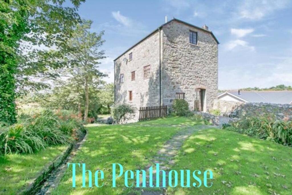 a large stone house with a grass yard at The Penthouse, top floor of a Grade II Listed Mill in Praze an Beeble