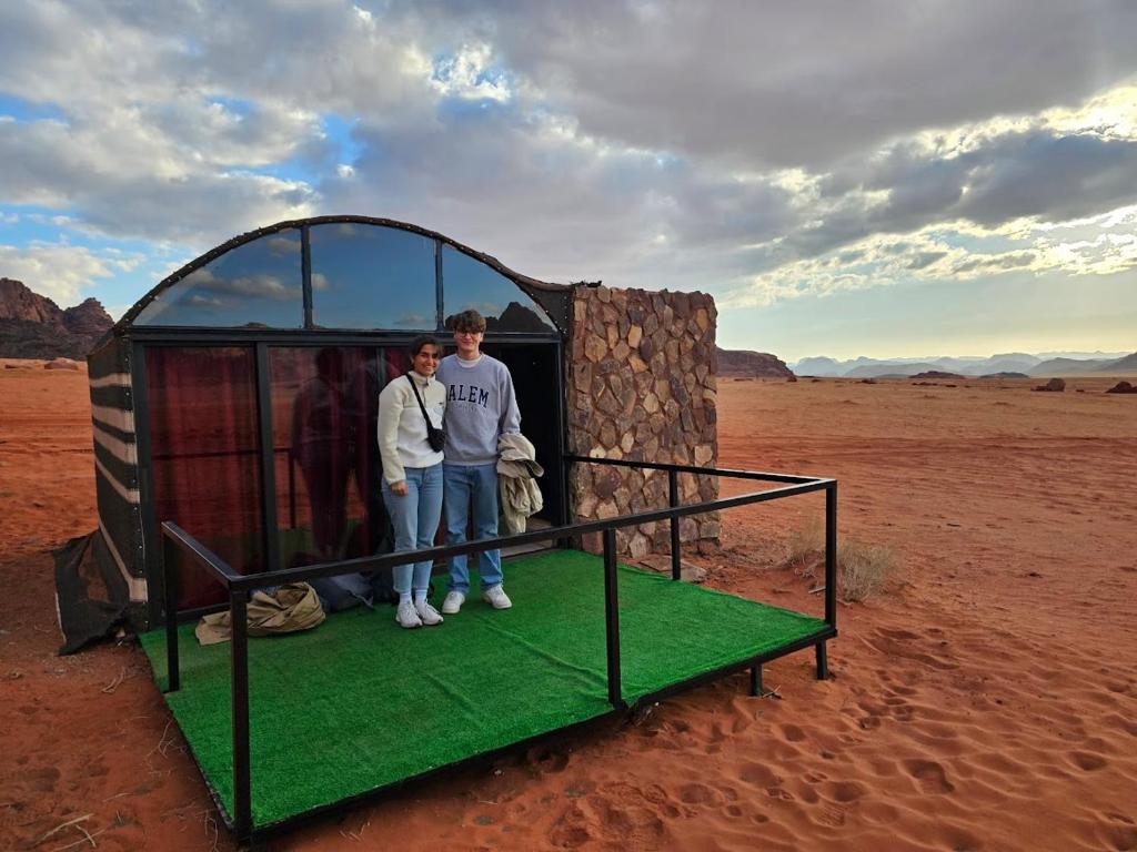 two men standing in a small building in the desert at Wadi Rum Desert Camp in Wadi Rum