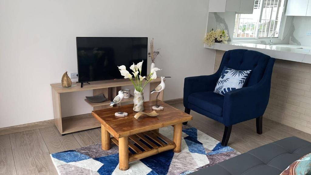 a living room with a blue chair and a coffee table at Mar y Tierra in Manta