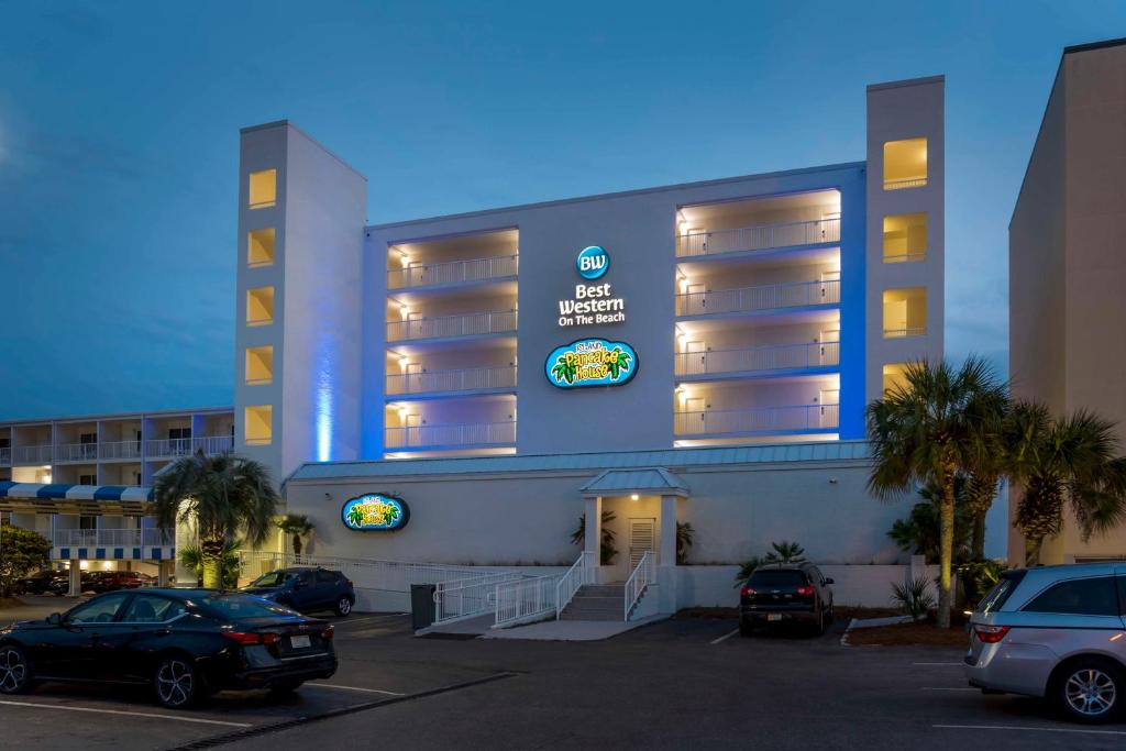 budynek hotelowy z samochodami zaparkowanymi na parkingu w obiekcie Best Western on the Beach w mieście Gulf Shores