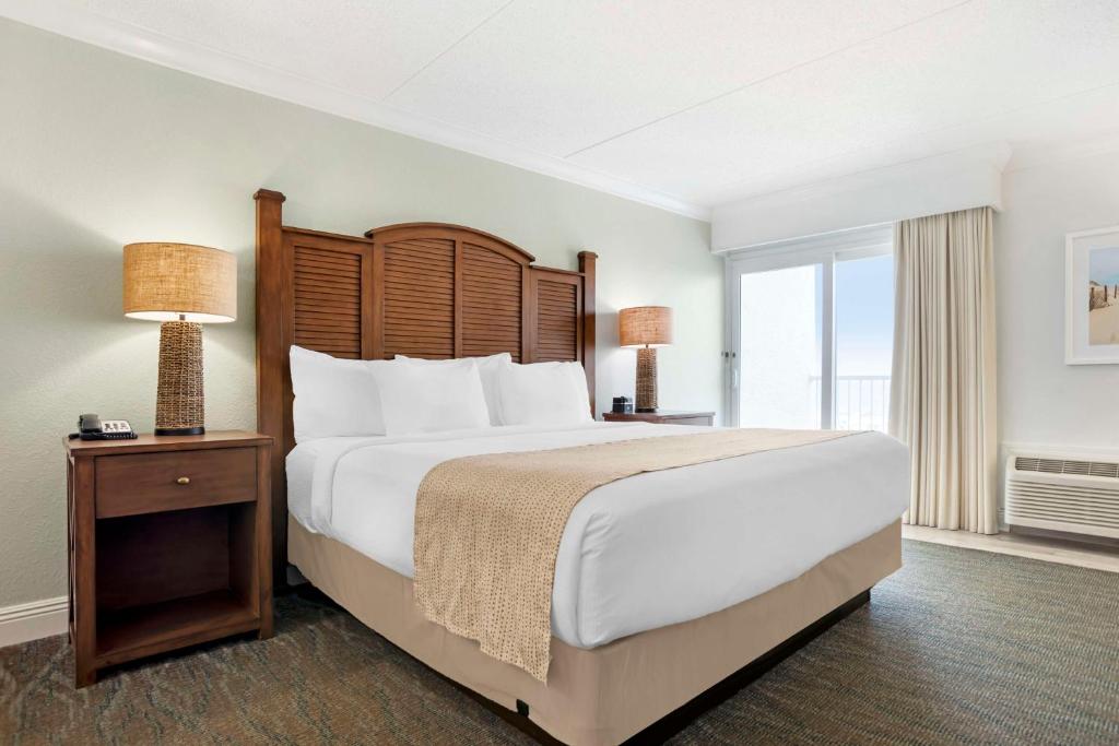 a bedroom with a large bed and a large window at Best Western on the Beach in Gulf Shores