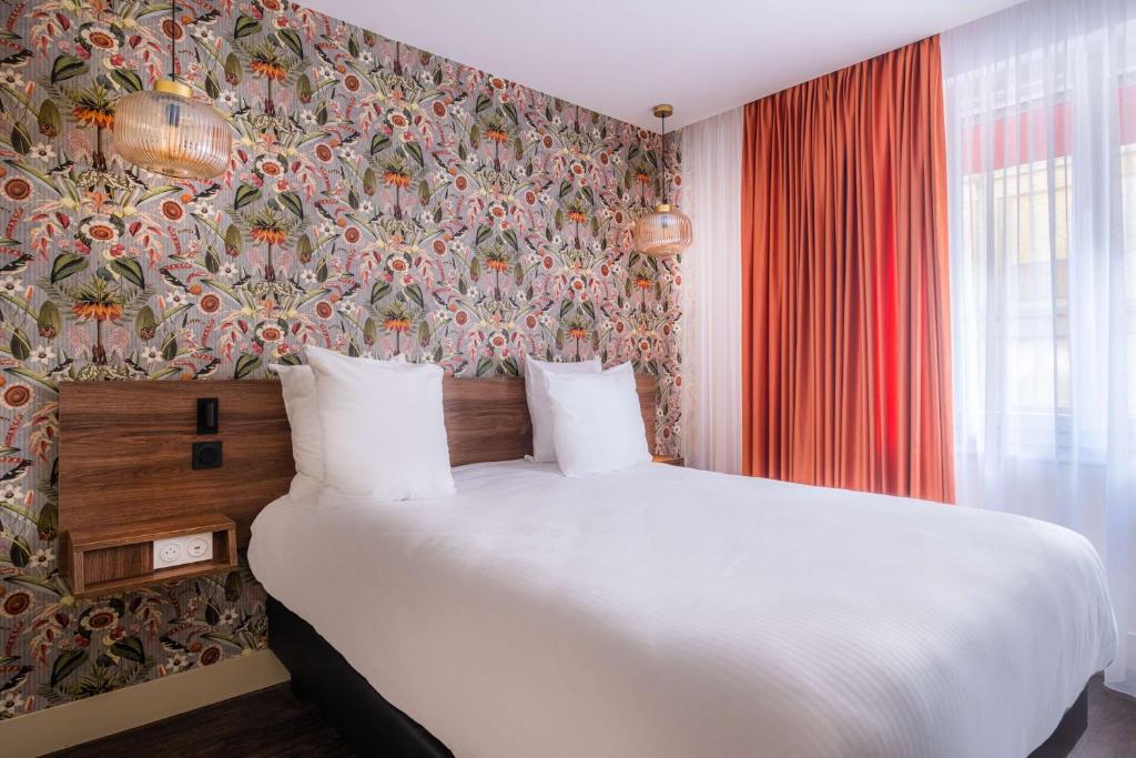 1 dormitorio con 1 cama blanca grande y papel pintado con motivos florales en Sure Hotel By Best Western Lorient Centre, en Lorient