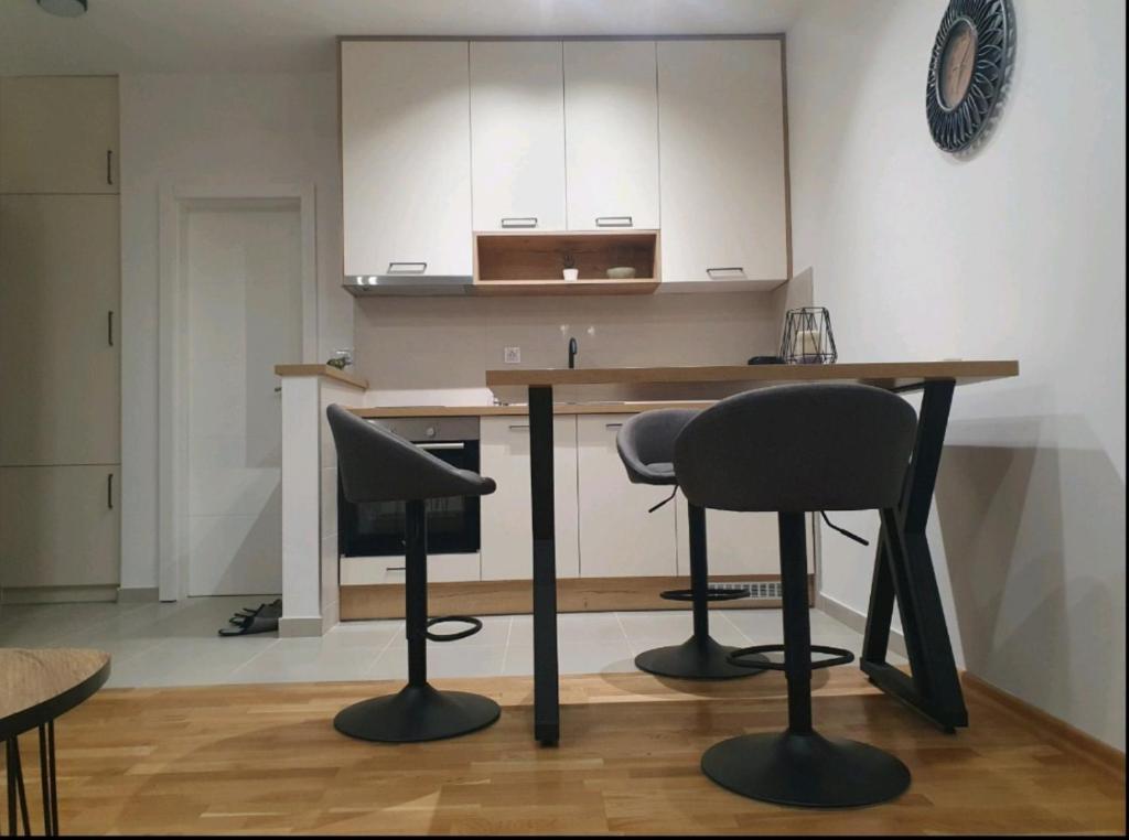 een keuken met een houten tafel en 2 stoelen bij ApartmanM&M in Banja Luka