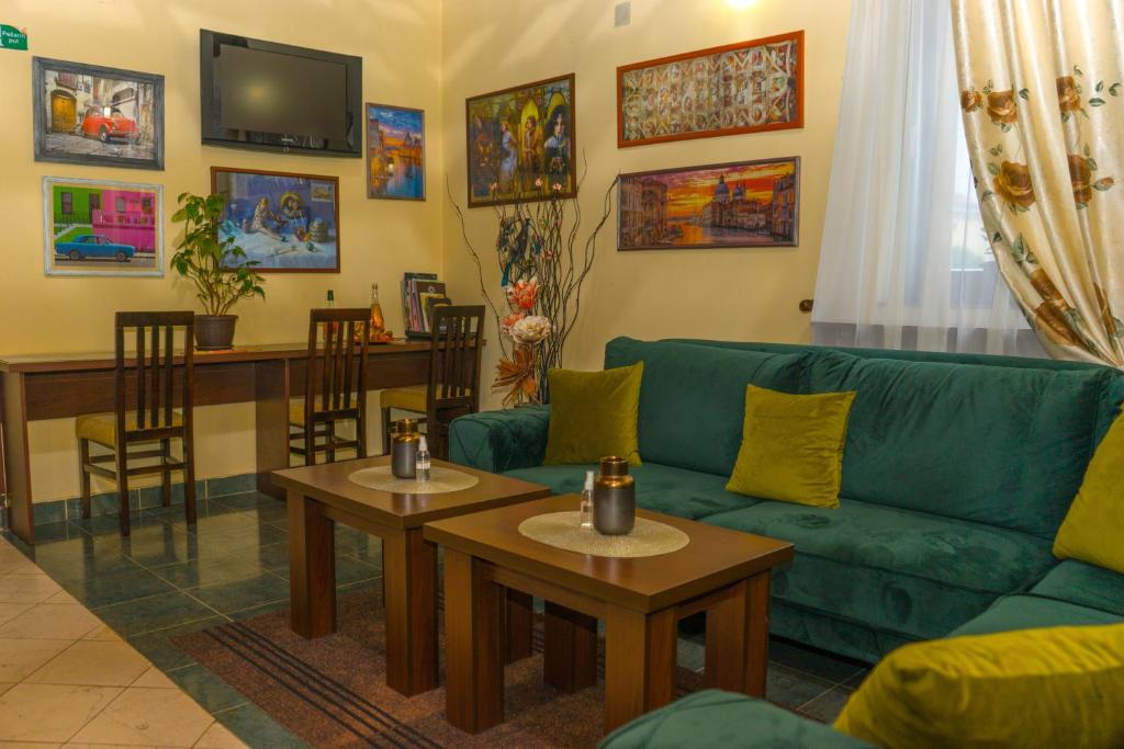 een woonkamer met een groene bank en tafels bij Garni Hotel City in Kruševac