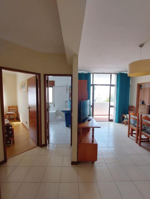 a living room with a television and a desk in a room at Coluna Mar in Quarteira