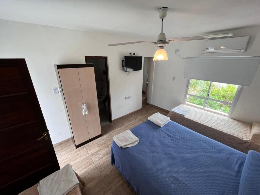 a bedroom with a blue bed and a window at Departamentos Salvador in Termas de Río Hondo