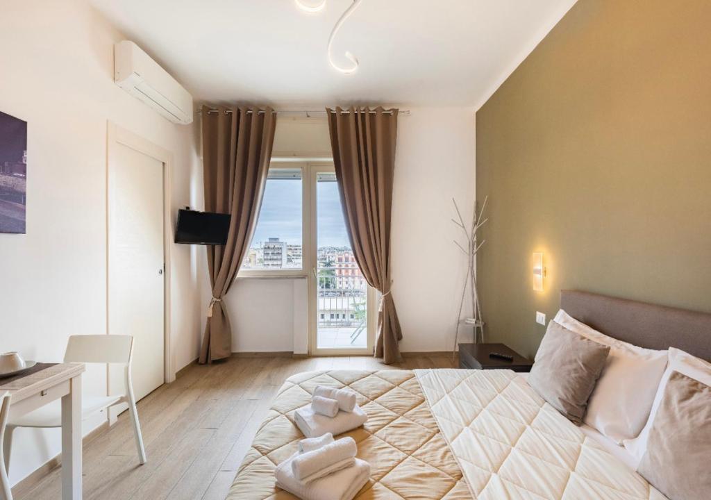 1 dormitorio con cama, escritorio y ventana en Capruzzi Guest House en Bari