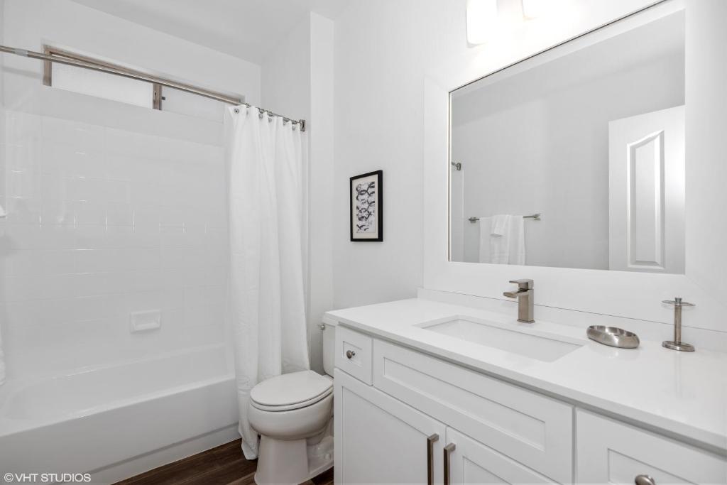 a white bathroom with a toilet and a sink at Pure Suites 2 Bed N Scottsdale McDowell Mtn Ranch Gym Pool in Scottsdale