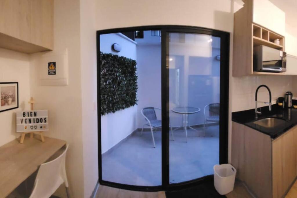 a kitchen with a glass door in a room at ¡Una escapada relajante en Lima! in Lima