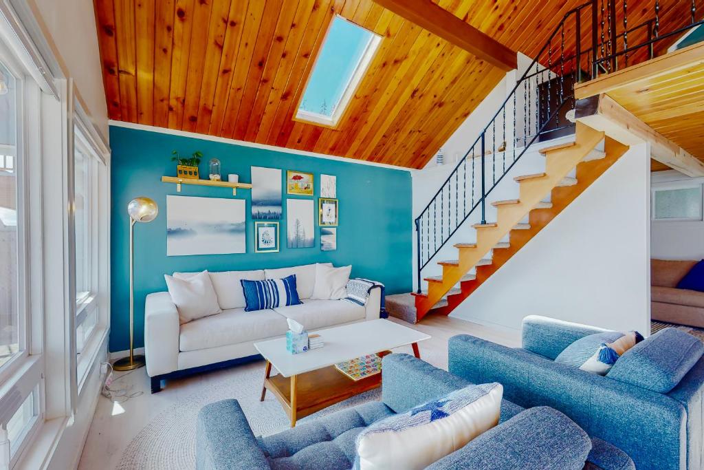 una sala de estar con muebles azules y blancos y una escalera. en Aquamarine Dreams, en Hoodsport