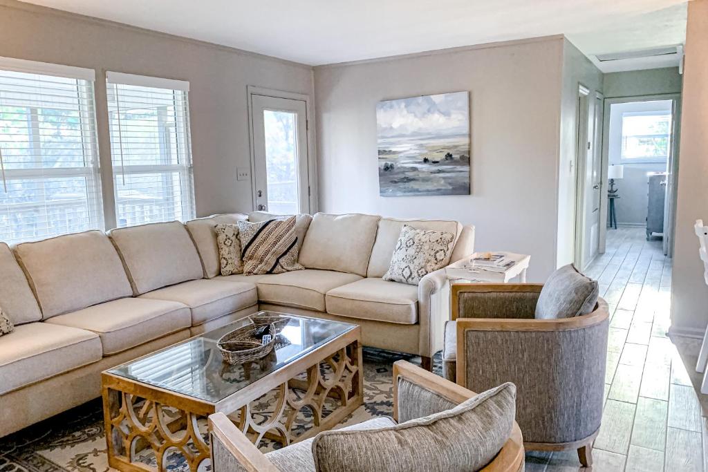uma sala de estar com um sofá e uma mesa em Sea Pine Cottage em St. George Island