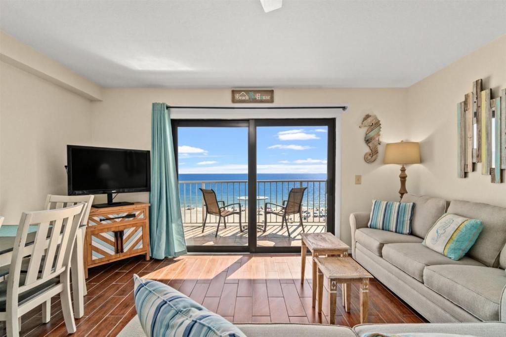 a living room with a couch and a television and a balcony at The Summit 731 in Panama City Beach