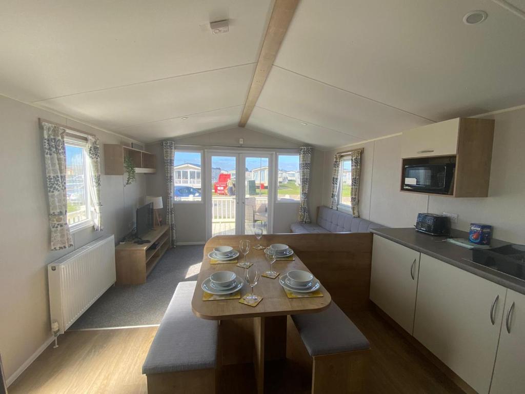 a kitchen with a wooden table in a room at Cosy holiday home at Romney Sands in New Romney