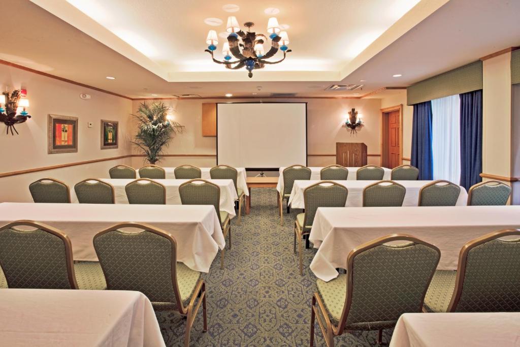 a conference room with tables and chairs and a whiteboard at Best Western Plus Orlando Lake Buena Vista South Inn & Suites in Kissimmee