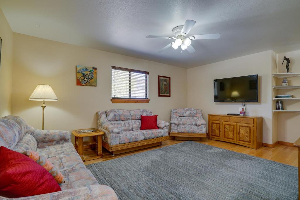 a living room with couches and a flat screen tv at Cozy Las Cruces Home - 2 Mi to New Mexico State! in Las Cruces