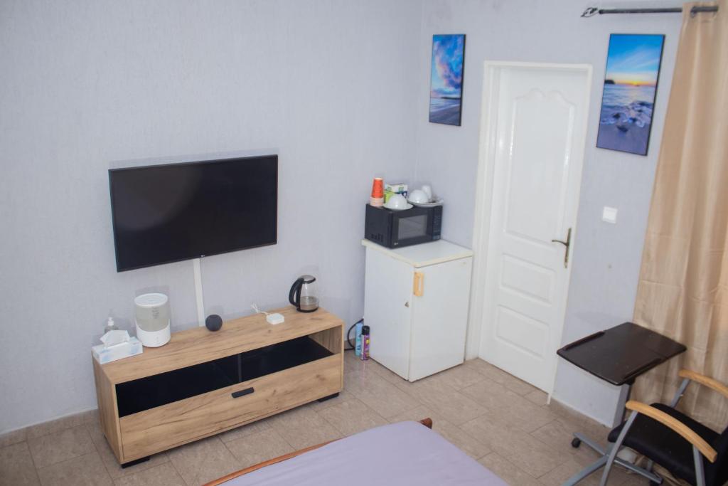 uma sala de estar com uma televisão de ecrã plano na parede em Studio cosy et moderne em Lomé