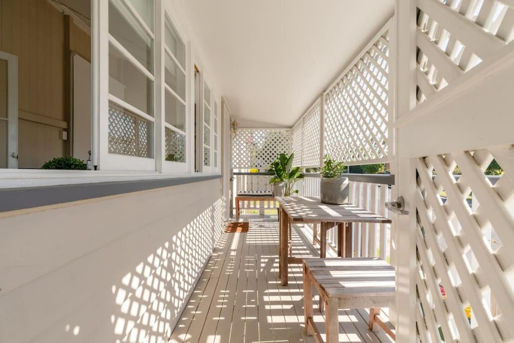 a porch with a table and benches on a building at Quaint & Cosy 1 Bedroom Apartment in Queenslander. in Brisbane