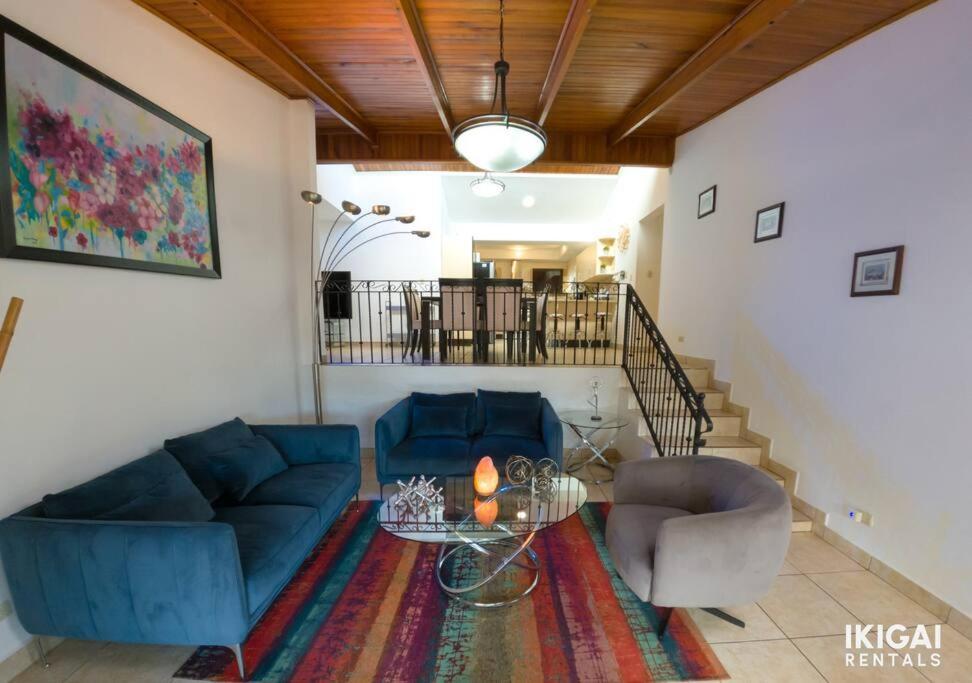 sala de estar con sofá azul y 2 sillas en Casa Rinu, en San José