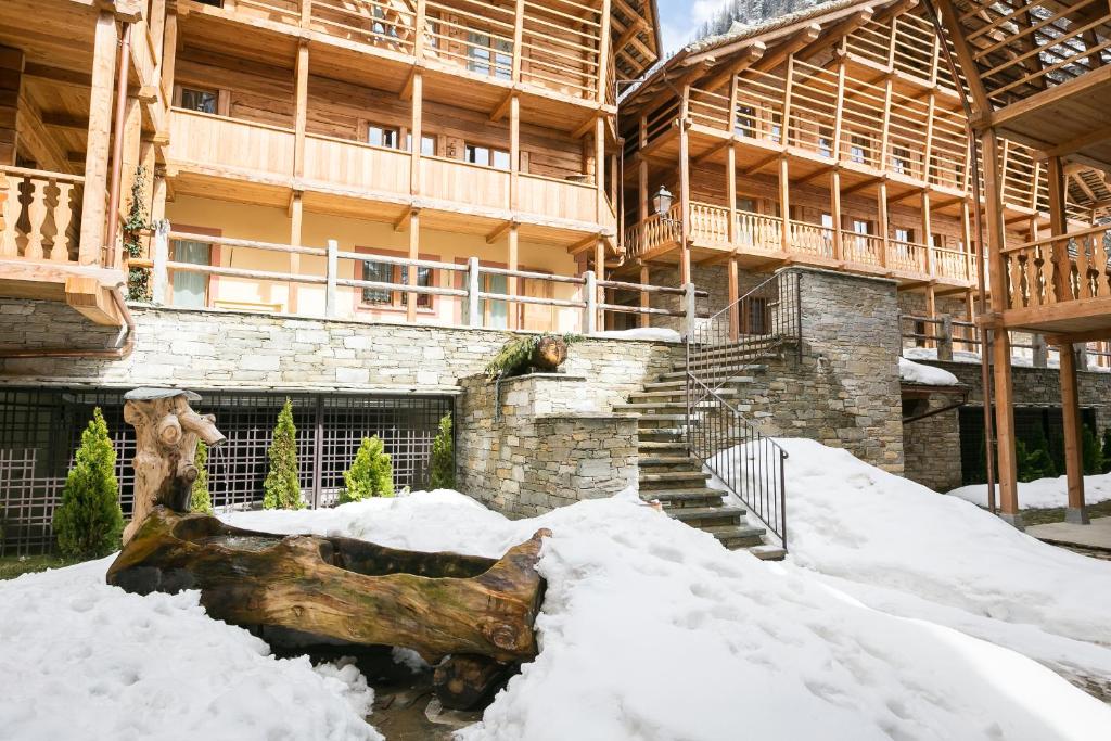 a large building with snow in front of it at Mirtillo Blu Family Apartment in Alagna Valsesia