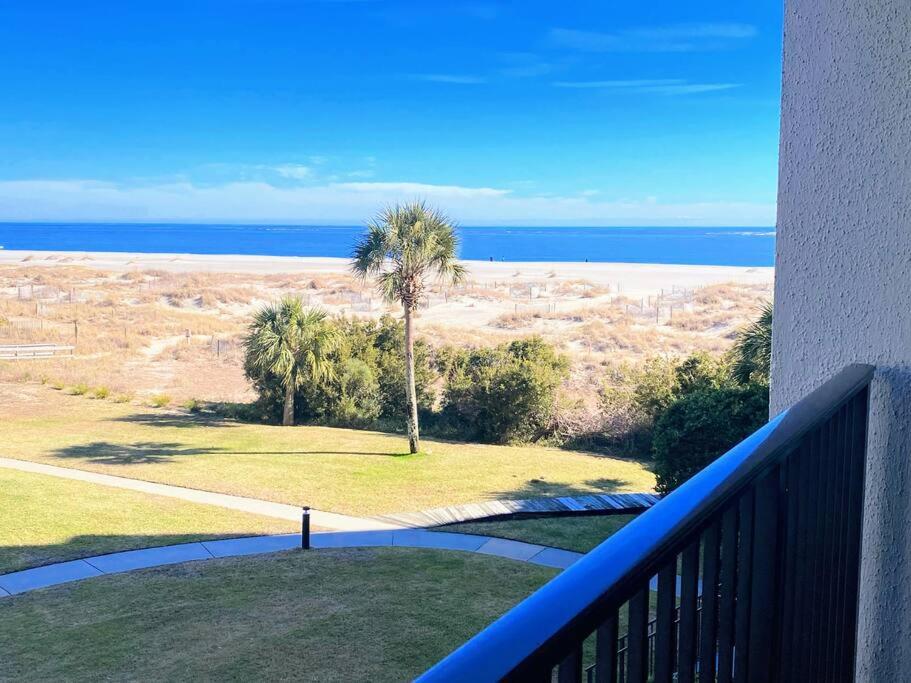 een balkon met uitzicht op een palmboom en de oceaan bij Summer House 204 - Newly Renovated! Ocean View! in Isle of Palms