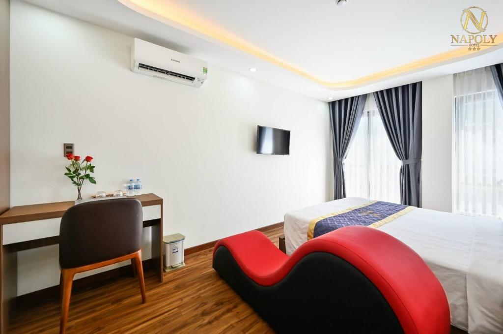 ein Hotelzimmer mit einem Bett, einem Schreibtisch und einem Stuhl in der Unterkunft Napoly Hotel in Vũng Tàu