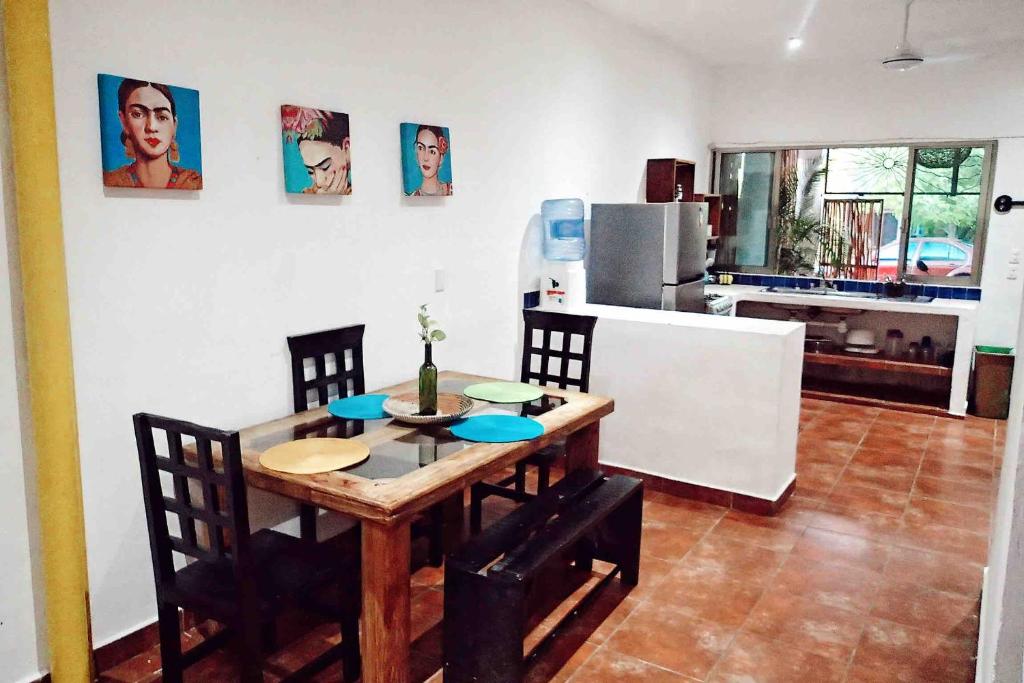 a kitchen with a table and chairs and a kitchen with a refrigerator at Kay Apartments Isla Mujeres in Isla Mujeres