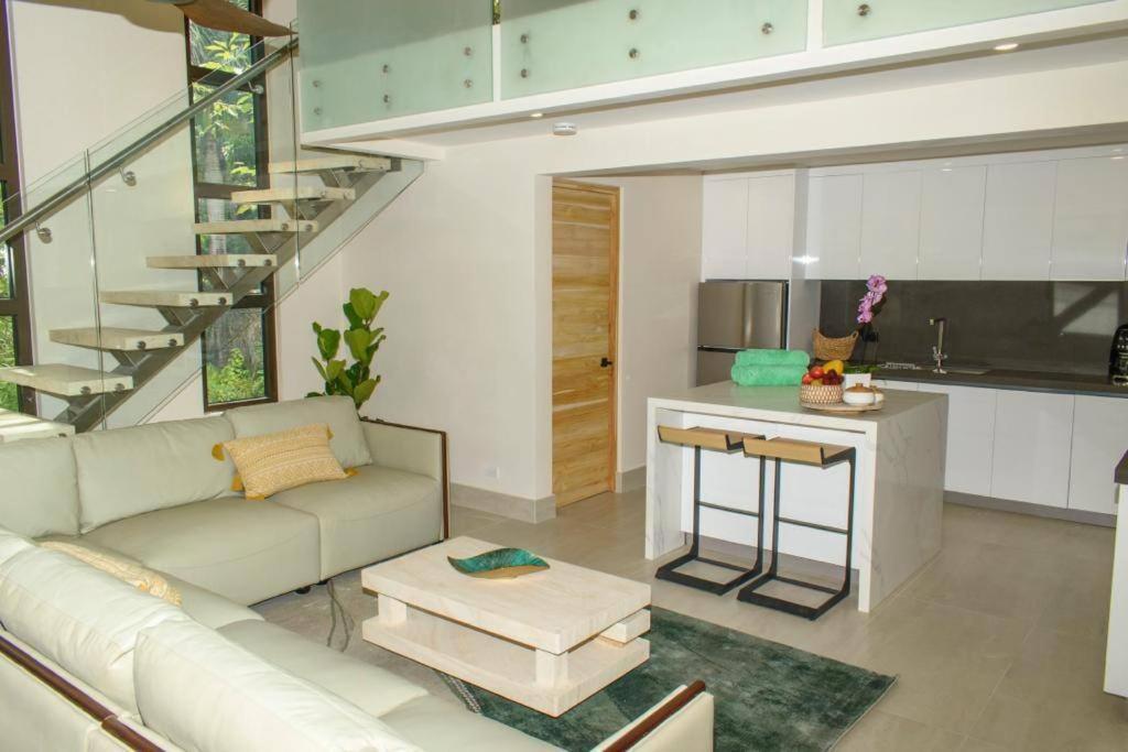 sala de estar con sofá y cocina en Casa Kaiman - Apartment Vista, en Nosara