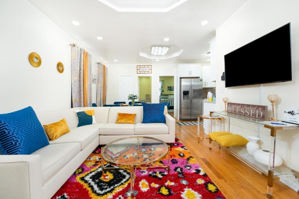 A slice of paradise awaits you! في بروكلين: غرفة معيشة مع أريكة بيضاء وتلفزيون بشاشة مسطحة